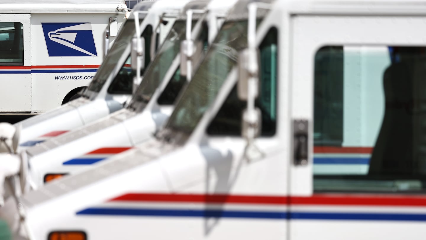 US Postal Service trucks parked at a post office.