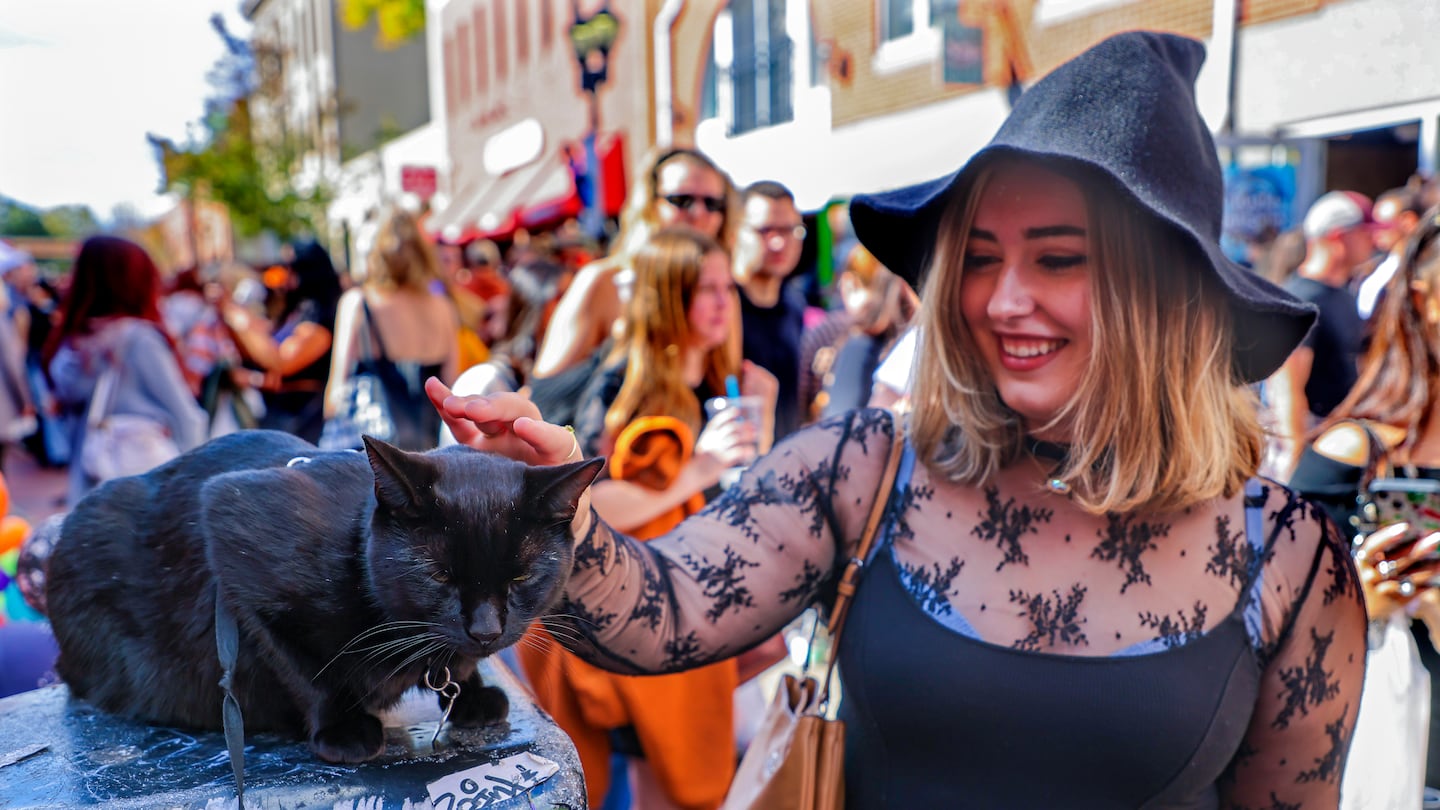 Mya Paquette, from Castleton, VT.  pet a black cat with no fear of bad luck during the Halloween festivities in downtown Salem. this month.