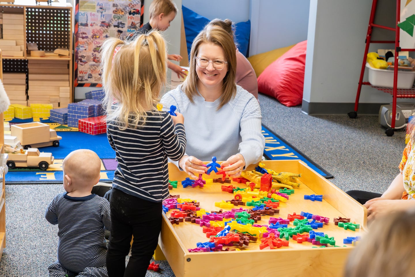 Anne Thornton, director of the North Central Michigan College Early Learning Center, played with infants and toddlers at a weekly playgroup.