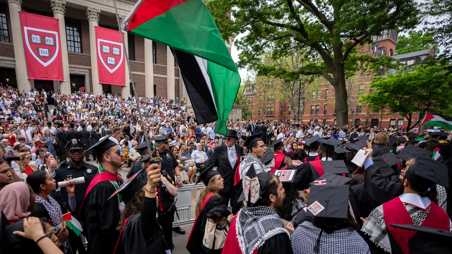 Graduating students held Palestinian flags and chanted as they walked out in protest over the 13 students who have been barred from graduating due to protest activities, during commencement in Harvard Yard, at Harvard University in May.