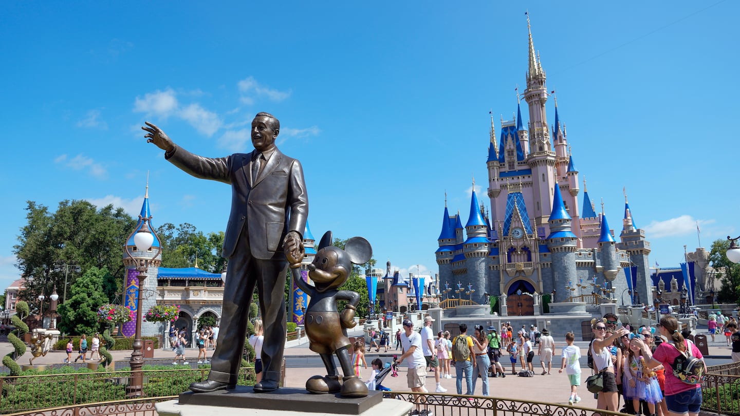 Guests pass a statue of Walt Disney and Mickey Mouse in the Magic Kingdom at Walt Disney World on July 14, 2023, in Lake Buena Vista, Fla.