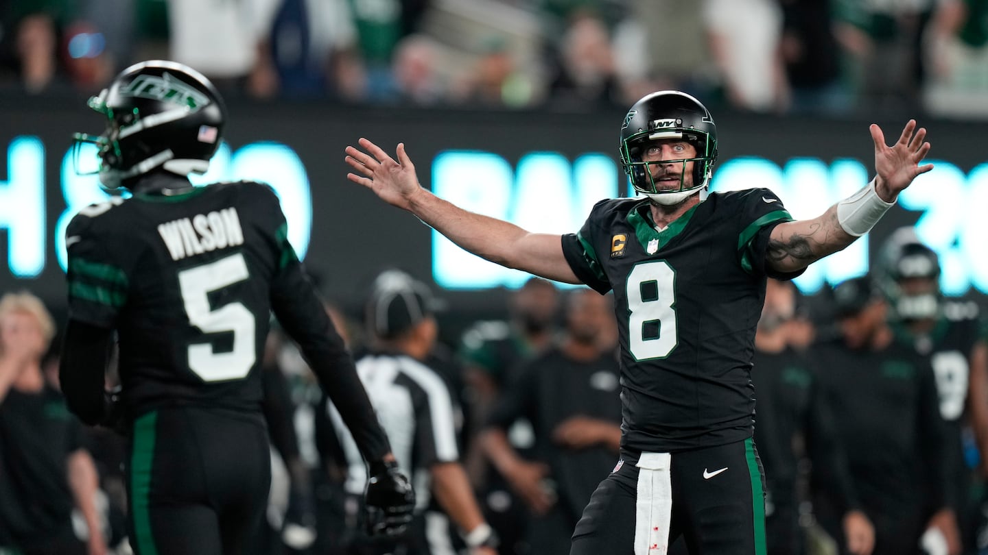 Aaron Rodgers celebrates after officials gave Garrett Wilson a touchdown on review.