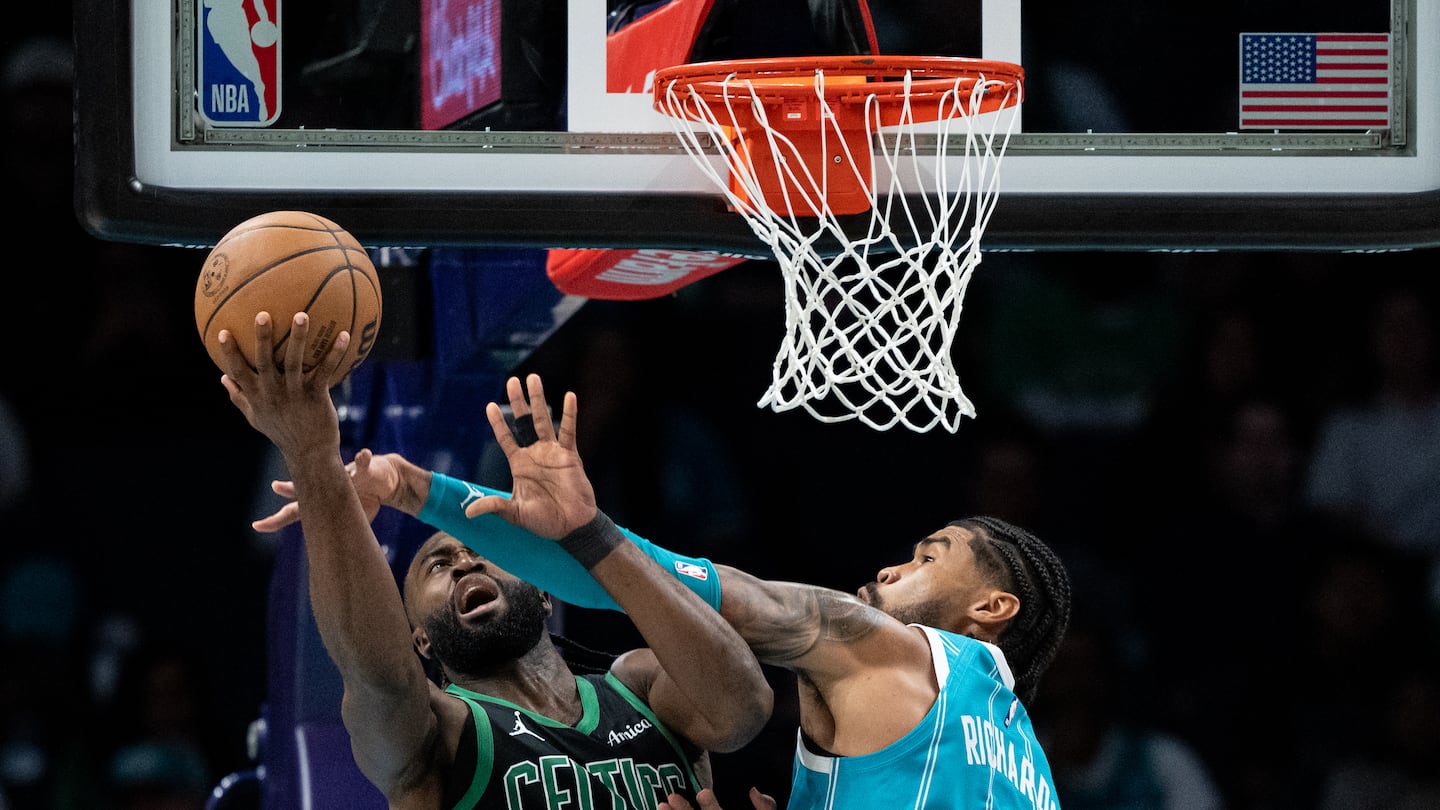 Jaylen Brown gets hacked by the Hornets' Nick Richards during Friday night's physical affair in Charlotte. 