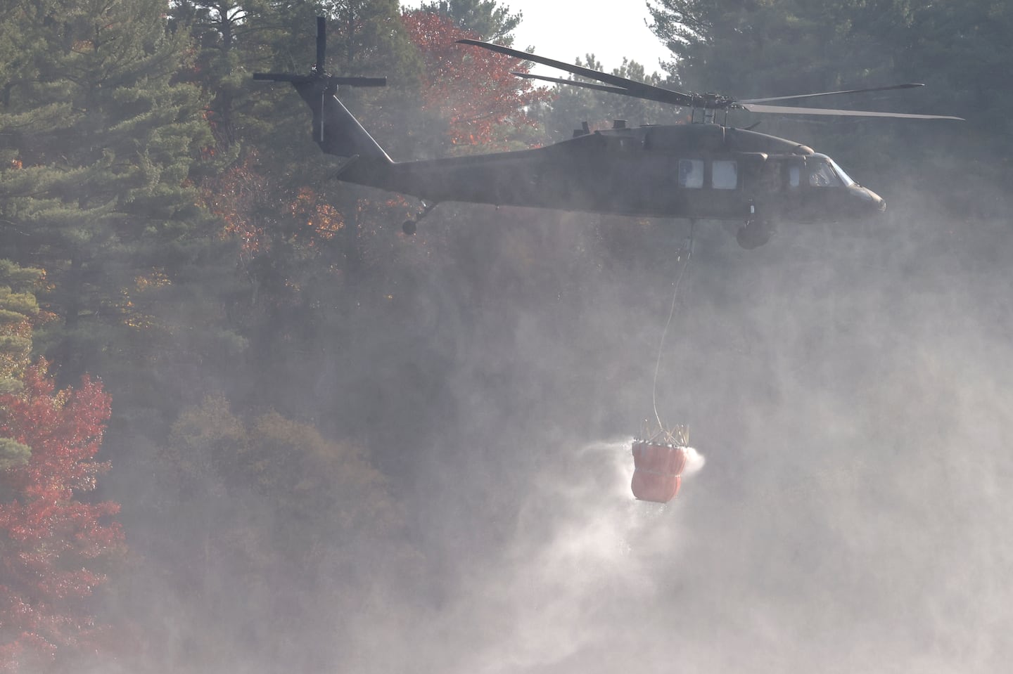 Massachusetts saw an unprecedented number of wildfires in October. Above, the Massachusetts Army National Guard helps battle a wildfire in the woods surrounding Middleton Pond.