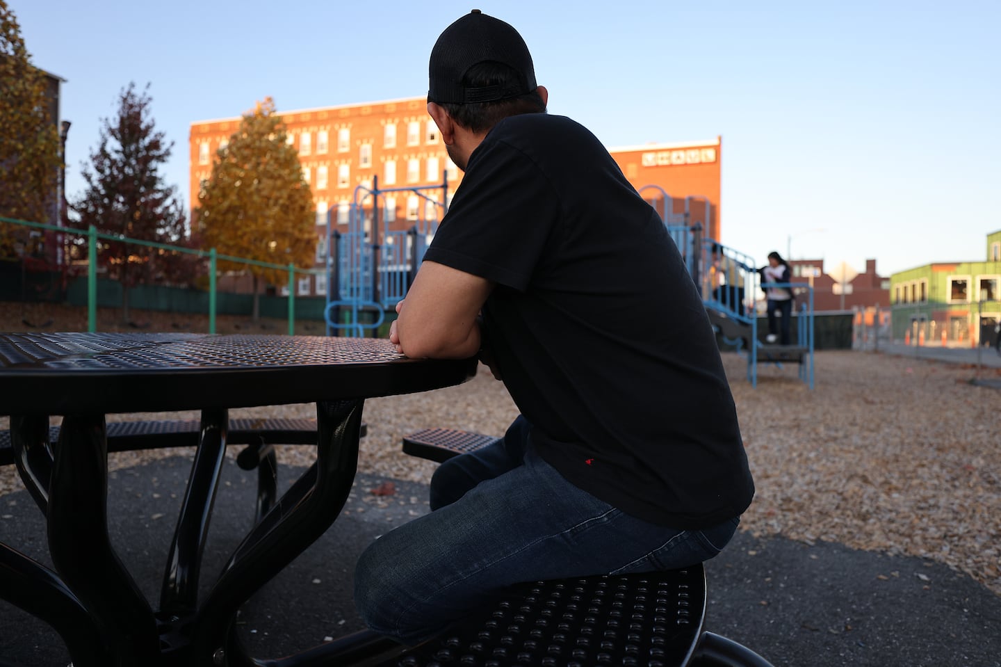 Alexander, a recent migrant from Ecuador, and his three children are living in a shelter in Holyoke. At times they have lived in his car. He watched his children play in a playground.