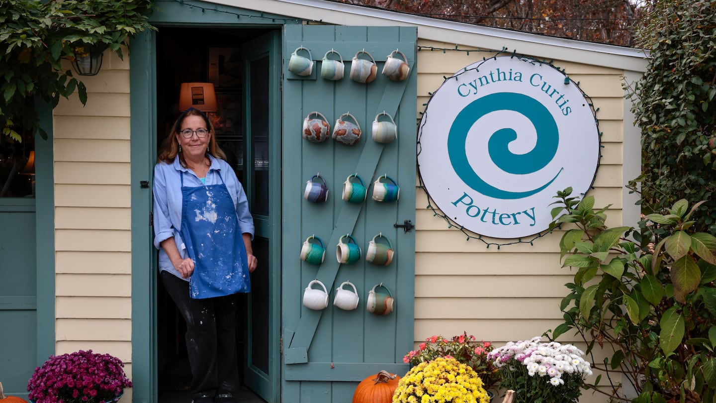 Potter Cynthia Curtis poses for a portrait at the shop outside her studio in Rockport.