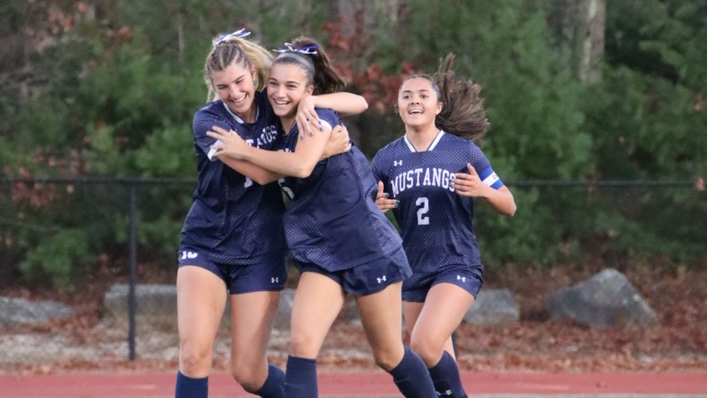 Eva Miranda (center) gets a warm embrace after scoring a goal in Medway's 3-1 victory over visiting Wilmington in their MIAA Division 3 girls' soccer tournament game on Tuesday.