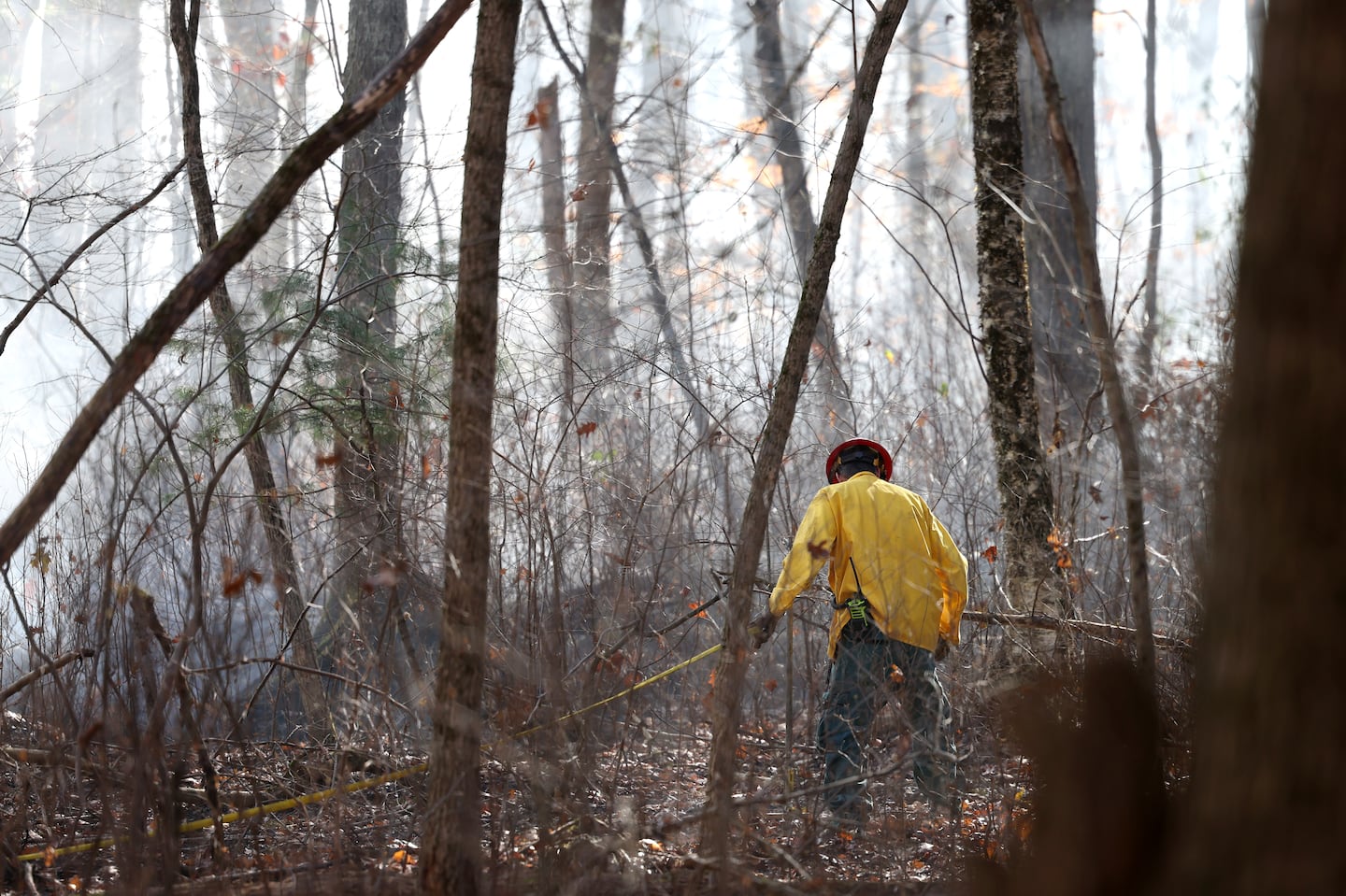 A firefighter worked to set up sprinklers around a brush fire in Middleton on Nov. 3.