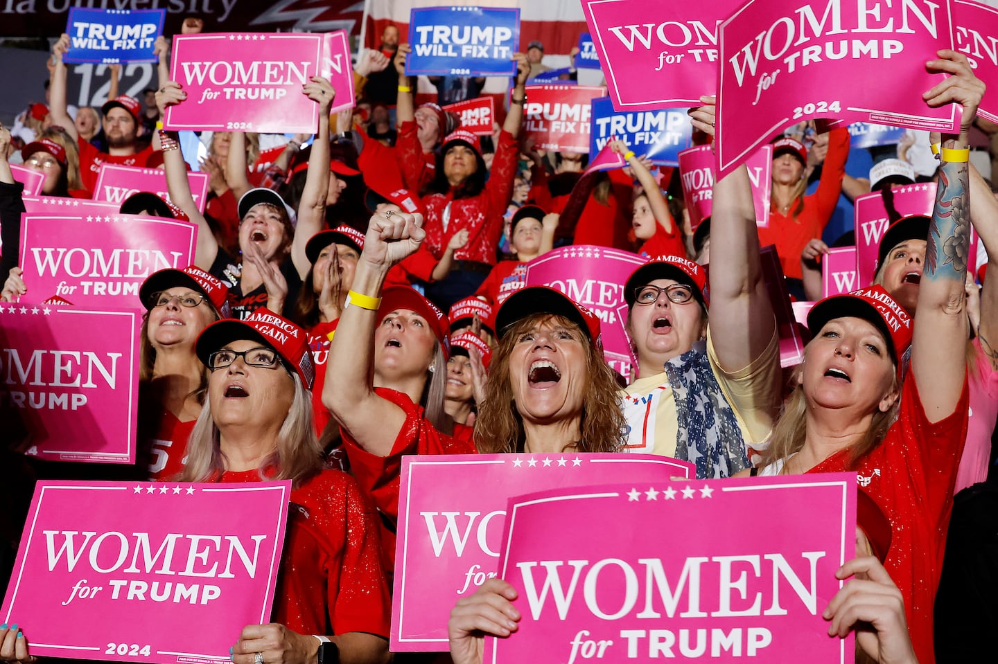 Supporters held "Women for Trump" signs as they watched Republican presidential nominee former president Donald Trump speak at a campaign rally at the Santander Arena on Nov. 4, in Reading, Pa.