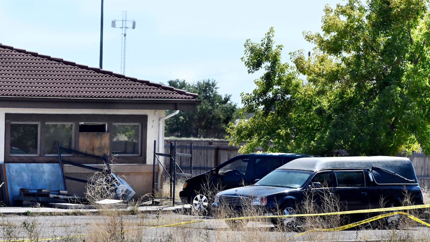 A hearse and debris can be seen at the rear of the Return to Nature Funeral Home, Oct. 5, 2023, in Penrose, Colo.