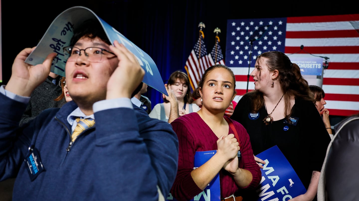 Arden Ferrari-Henry, center, a Suffolk University Student, watches the election results before the start of the an Election Night Watch Party hosted by the Massachusetts Democratic party at SoWa Power Station.