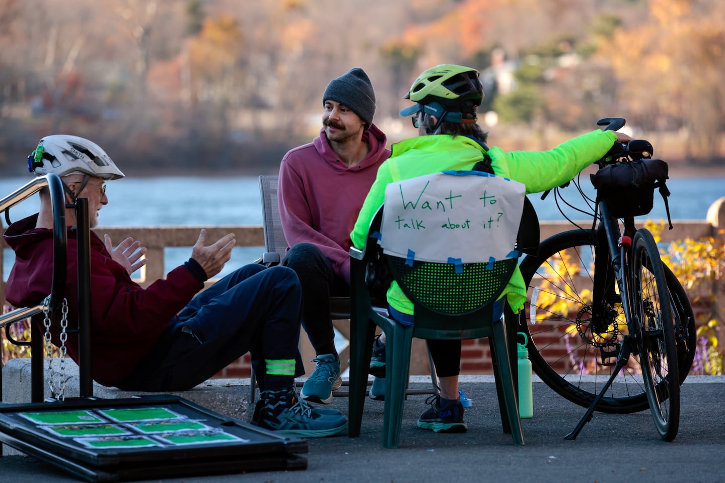 Eben Kunz, left, and Gail Boettiger, right, take a break from their bike ride to talk with Ben (who asked to be identified by his first name only), near the boathouse on Jamaica Pond. Following the election Ben and his friend Alexander Kelly decided to set up shop for impromptu therapy, or what Ben referred to as, public listening.