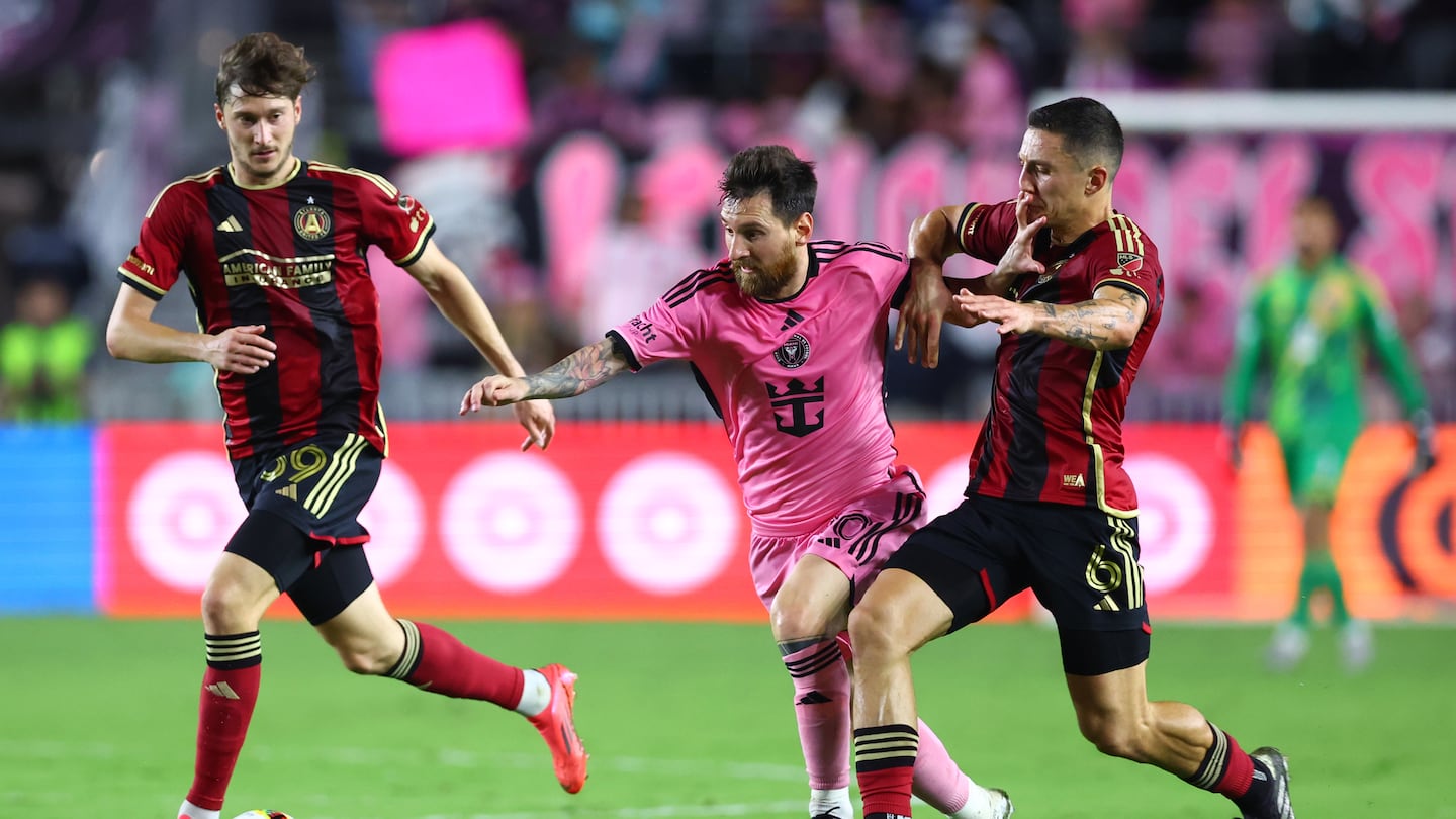 Inter Miami's Lionel Messi fights through Atlanta United players Aleksey Miranchuk (left) and Bartosz Slisz during Atlanta's playoff victory. 