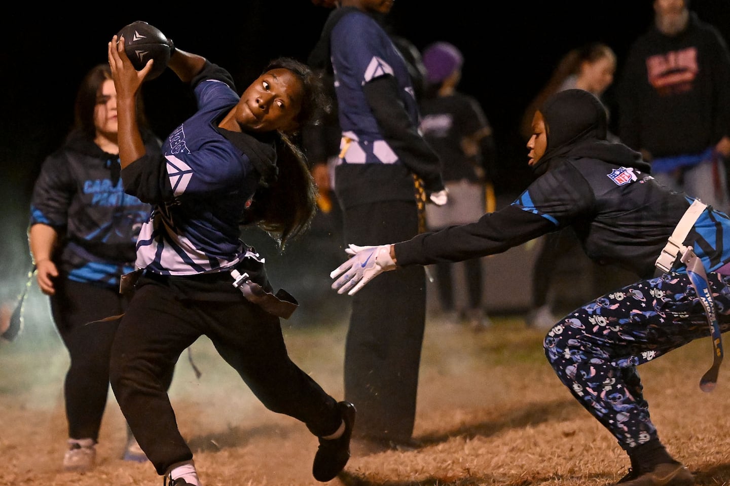 Taleah Simmons of the Cowboys (left) showed some moves as Cyniah Barr of the Panthers lunged for her flag during a Leominster league game Oct. 28.