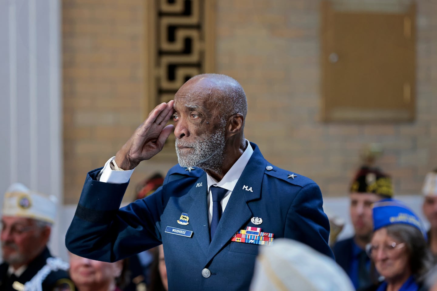 Brigadier General Enoch “Woody” Woodhouse II, 98, saluted as he entered the Hall of Flags during a Veterans Day ceremony at the State House on Monday.