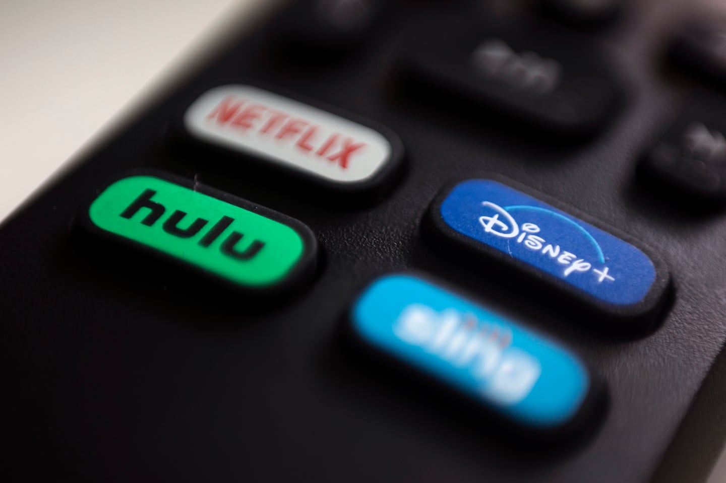 The logos for streaming services Netflix, Hulu, Disney+, and Sling TV are pictured on a remote control on Aug. 13, 2020, in Portland, Ore.