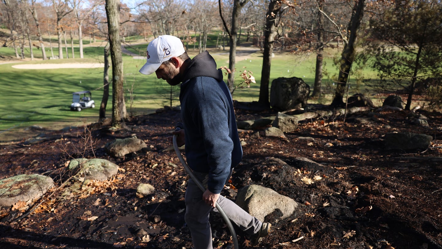 Kyle Levesque, superintendent at Gannon Golf Club in Lynn, used a hose to put out a hotspot that was encroaching on the golf course Tuesday.