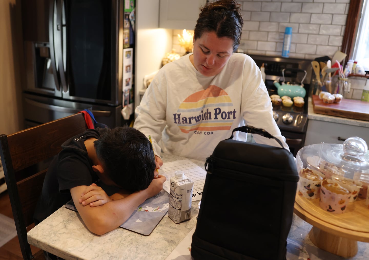 Jonathan Pagan put his head down as his mom, Jenni, wrote in the answers he gave her as they worked to complete a worksheet that asked him questions about his reading level and interests. Pagan is entering the fourth grade and only recently learned his letters despite being in a specialized district program.