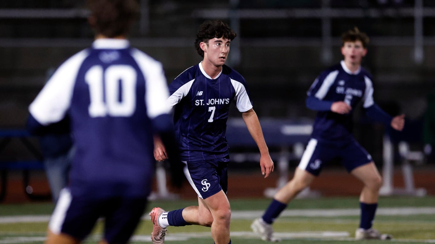 Finn McCabe dribbles upfield as he looks for an open St. John's Prep teammate.