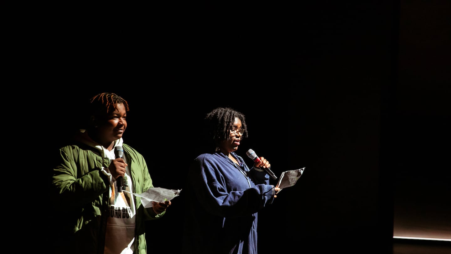 Two Lavine Learning Lab students welcome audience members to an ART performance.