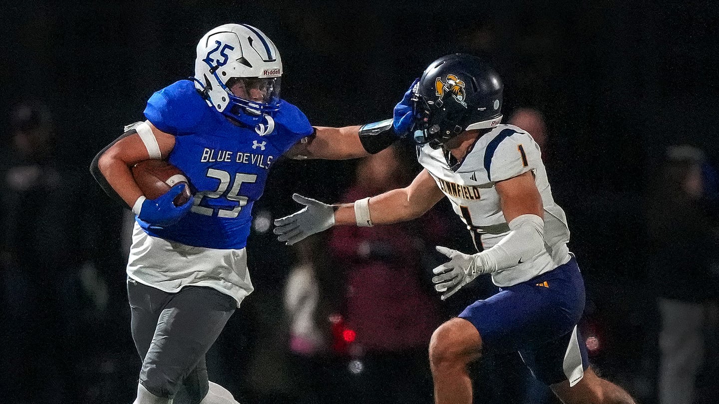 Fairhaven’s Justin Marques (left, No. 25) stiff arms Lynfield’s Jesse Dorman, (right, No. 1) as he runs for a first down. Marques rushed 40 times for 193 yards and four touchdowns to set a state record with 103 career TD runs, and came up with game-saving interception on Lynnfield's tying 2-point conversion attempt in a 36-34 overtime win in Friday's Division 6 quarterfinal.