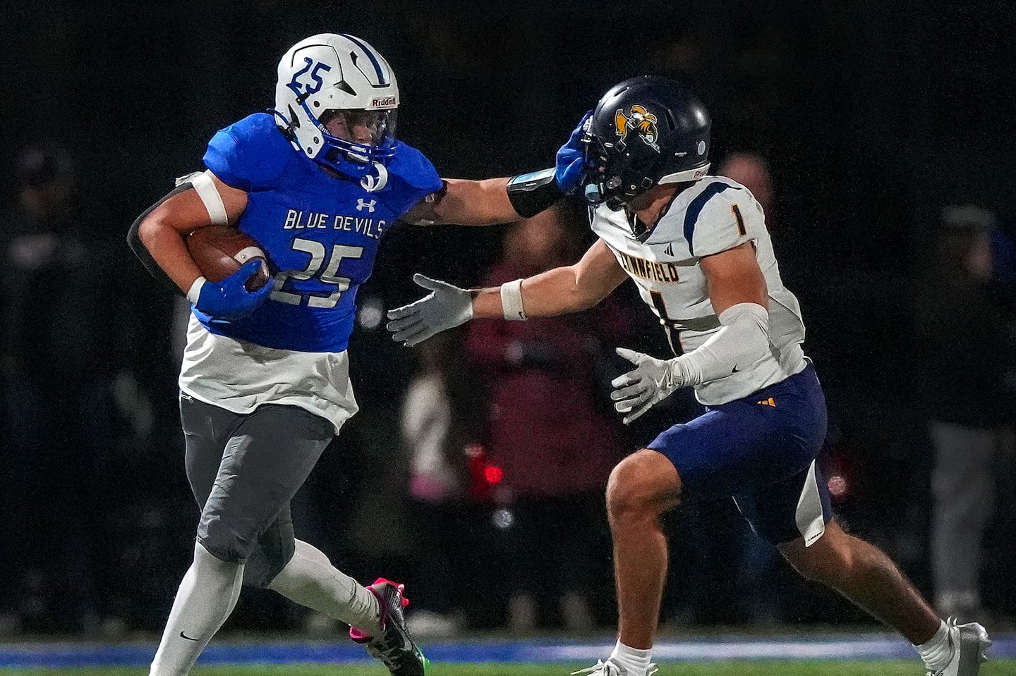 Fairhaven’s Justin Marques (left, No. 25) stiff arms Lynfield’s Jesse Dorman, (right, No. 1) as he runs for a first down. Marques rushed 40 times for 193 yards and four touchdowns to set a state record with 103 career TD runs, and came up with game-saving interception on Lynnfield's tying 2-point conversion attempt in a 36-34 overtime win in Friday's Division 6 quarterfinal.