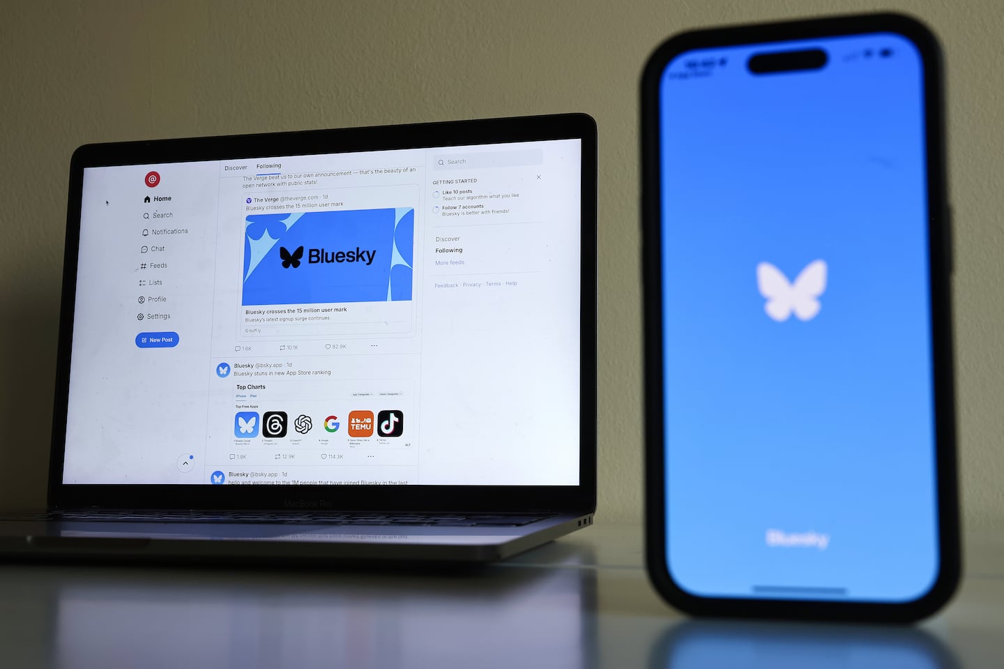 The Bluesky logo, on a computer monitor and a cellphone.