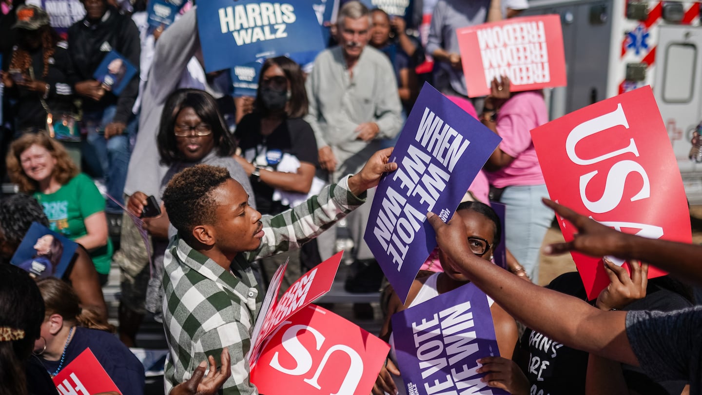 A campaign staff member handed out signs to the crowd as Vice President Kamala Harris prepared to speak during a presidential campaign rally in Atlanta on Nov. 2.