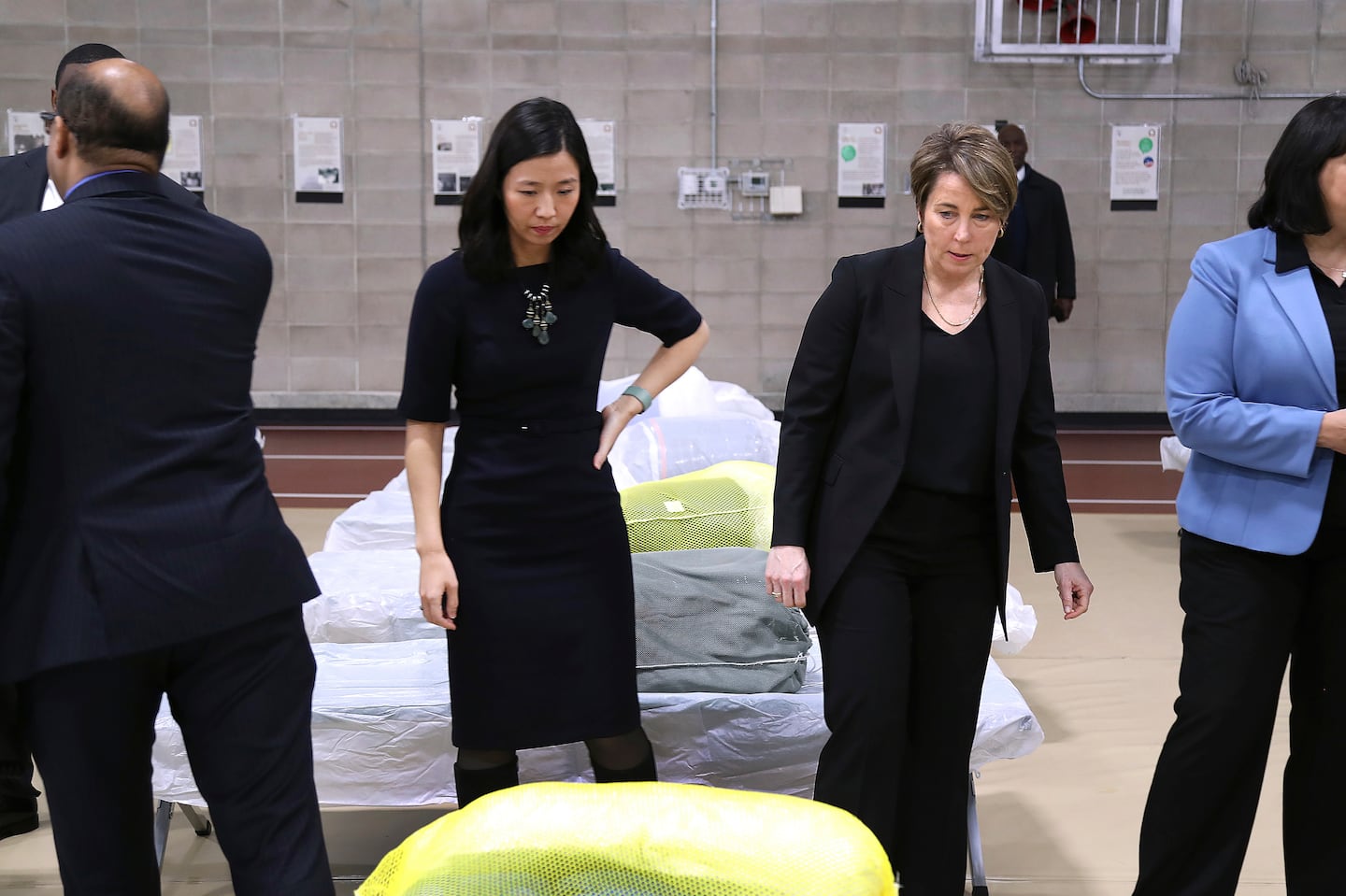 Boston Mayor Michelle Wu (left) and Massachusetts Governor Maura Healey paused to look at the Army cots set up on the gym floor as state and local officials toured the Melnea A. Cass Recreational Complex in Roxbury in January.