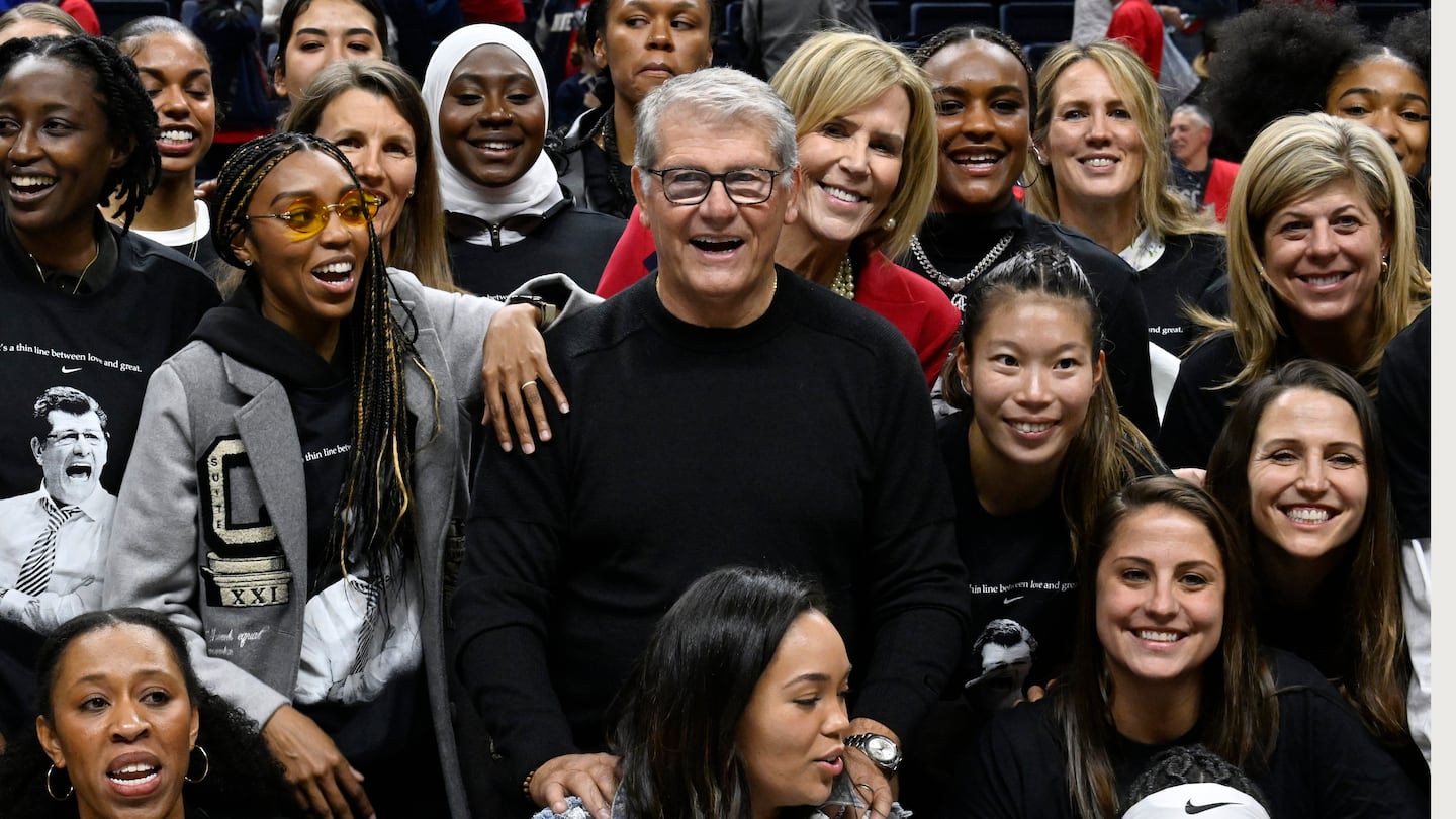 UConn coach Geno Auriemma poses for a photograph with his players past and present and coaches as he is honored for the most wins in college basketball history.