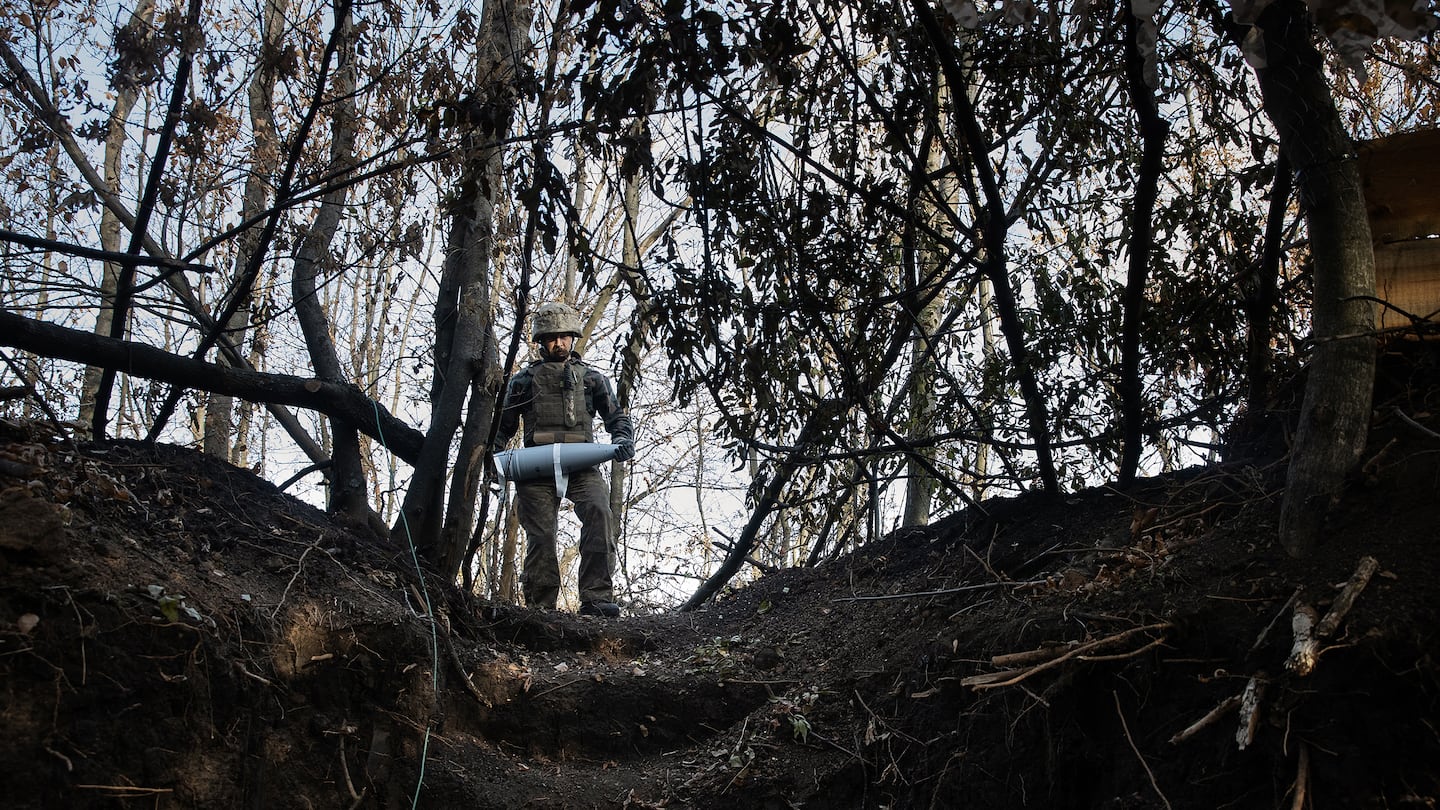 A Ukrainian soldier from the 38th Separate Marine Brigade carries a shell to a field gun being fired at the advancing Russian Army, in the Donetsk Oblast on Nov. 16.