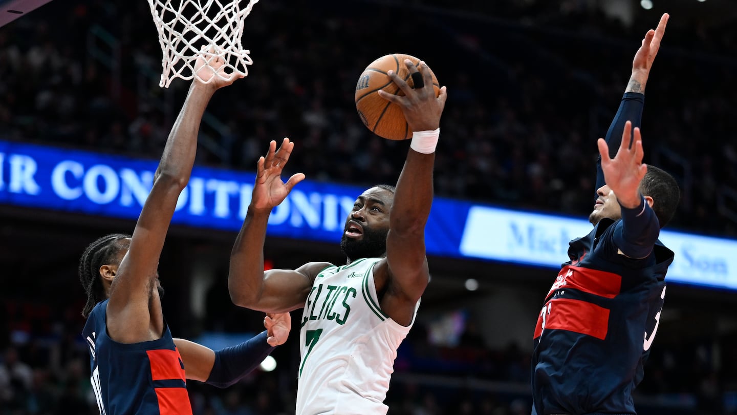 Celtics guard Jaylen Brown drives between Wizards Kyshawn George (left) and Kyle Kuzma for two of his game-high 31 points as Boston overcame an ugly shooting night to win in Washington. 