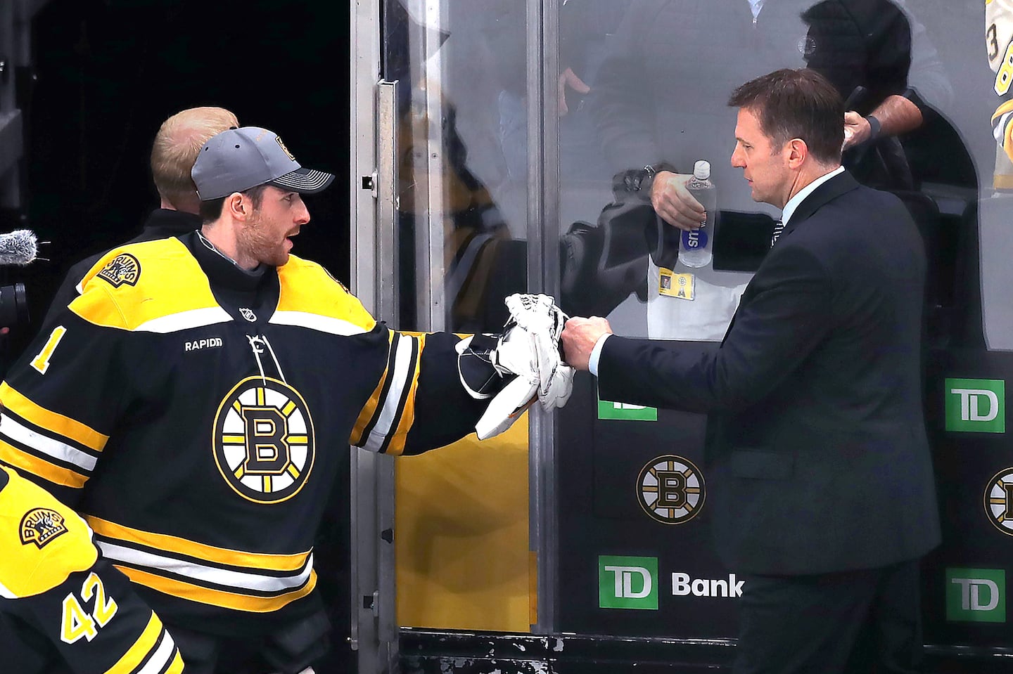 Joe Sacco (right) got a fist-bump from Jeremy Swayman after the Bruins notched a win in his first game as interim head coach.