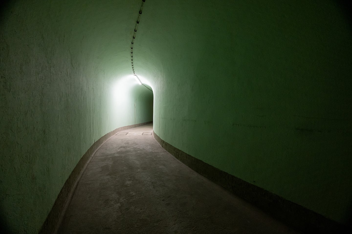 The oval shape of a corridor inside bunker K-35 near the village of Škrilj, Slovenia, was designed to release the power of a nuclear shock wave. Beyond this opening is a 5-ton steel door. The reinforced concrete walls of the bunker are nearly 5 feet thick.