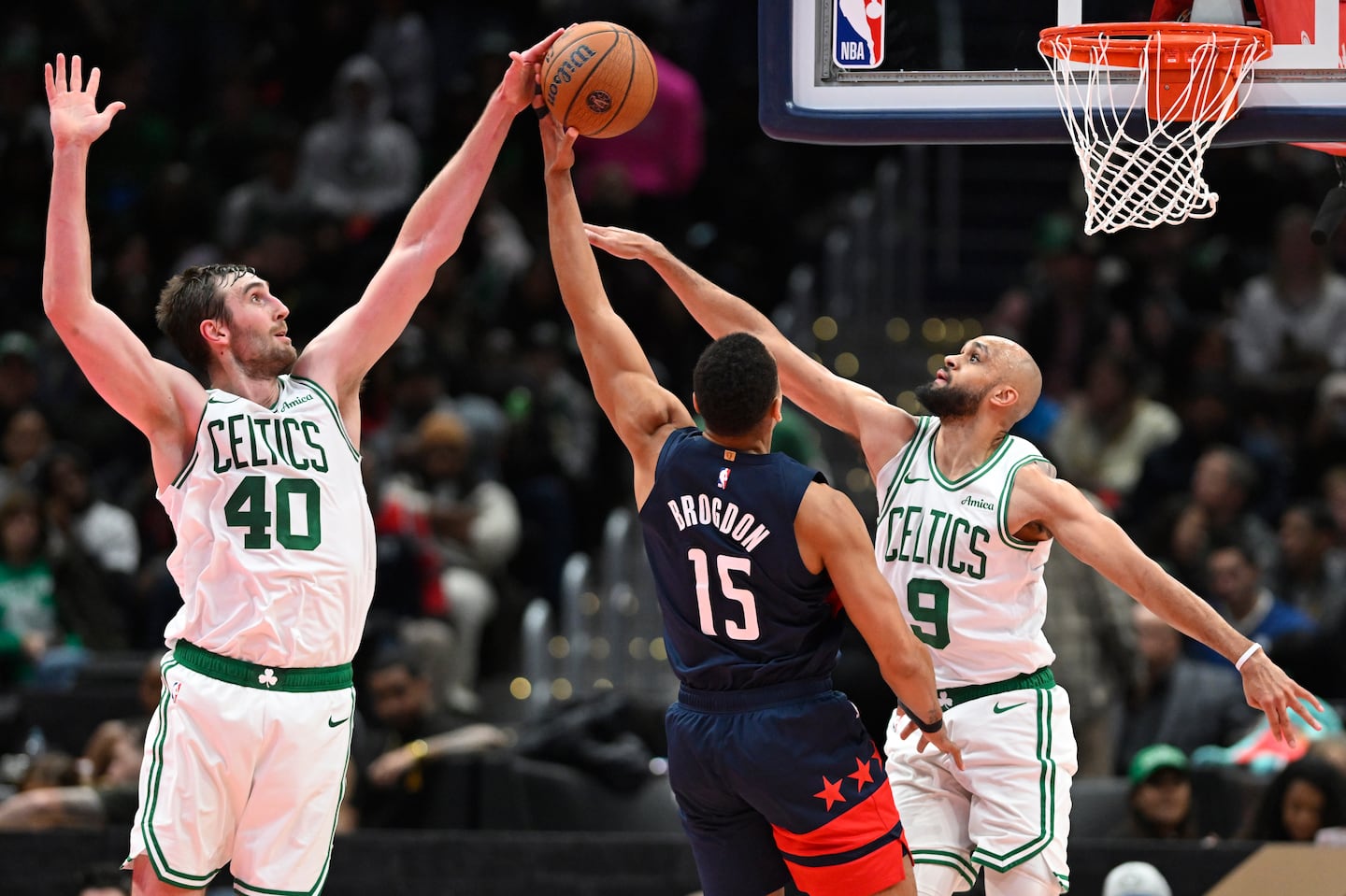 The Wizards' Malcolm Brogdon went for 18 points and 10 rebounds against his former team, but was denied on this shot attempt by Luke Kornet (left) and Derrick White.