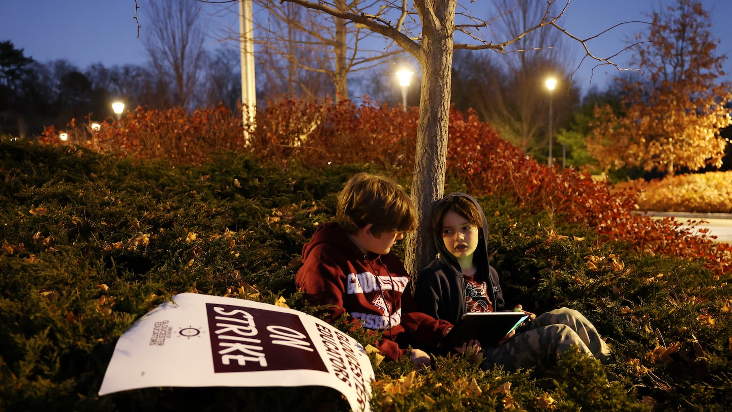 Fourth-graders Dante Favazza (left) and Llewyn Plaisted sat under a tree Nov. 19 as their mothers, both teachers at West Parish School, rallied with their fellow Union of Gloucester Educators outside the school. Negotiations to resolve the teachers strike went on inside.