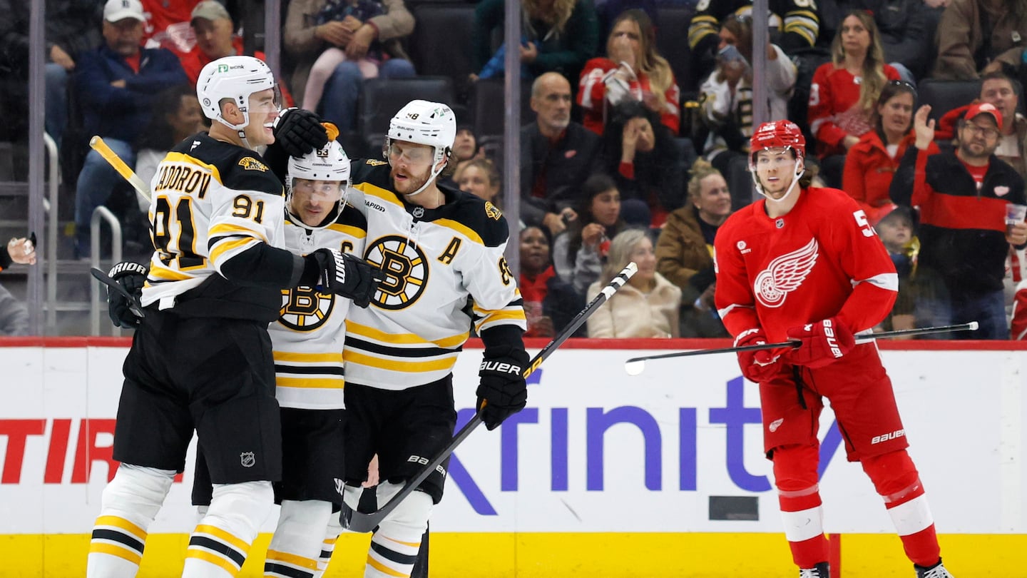 Boston captain Brad Marchand (second from left) celebrates with teammates Nikita Zadorov (91) and David Pastrnak after scoring the go-ahead goal 8:30 into the third period in Saturday's 2-1 win in Detroit. 