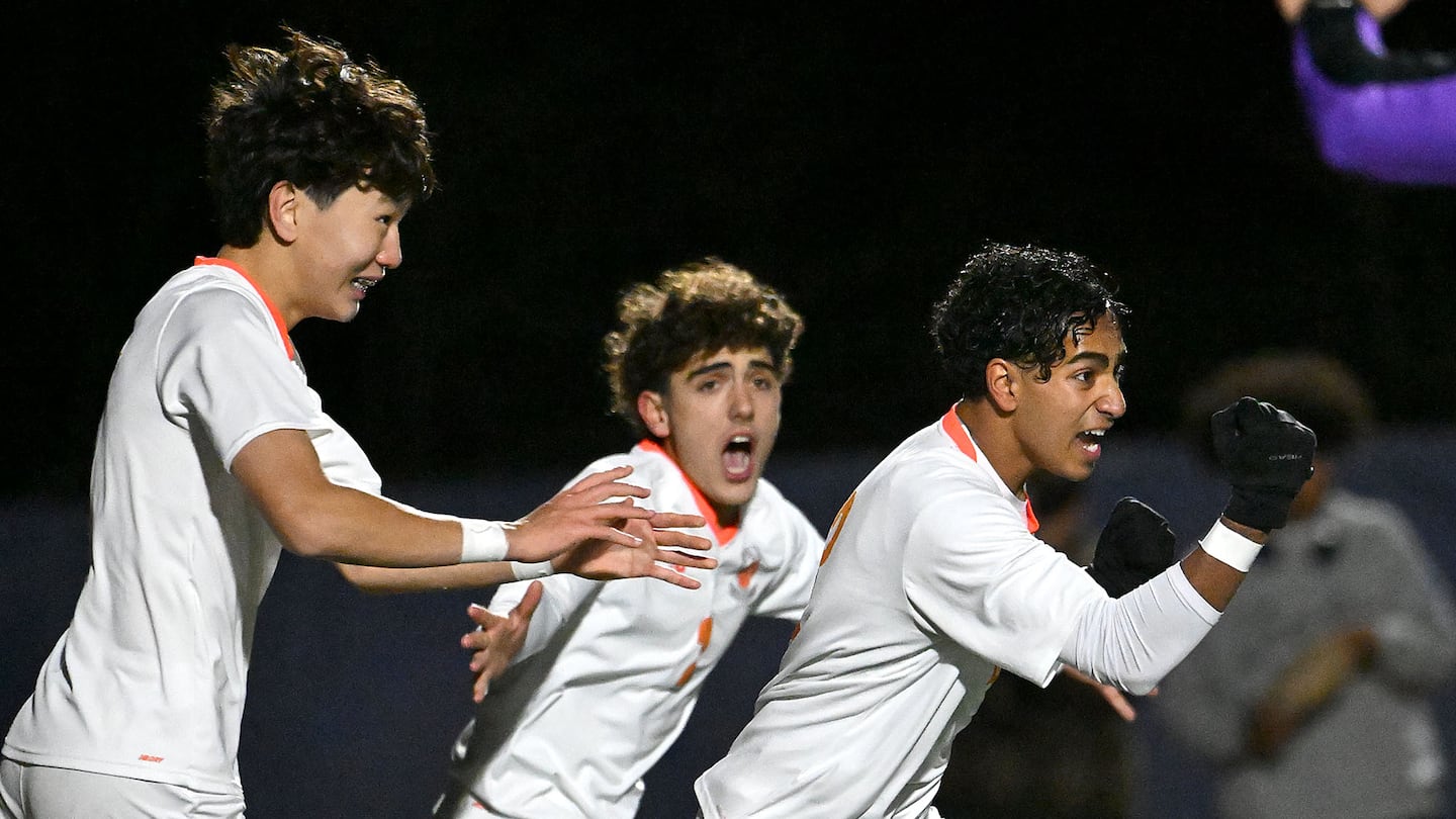 Newton North’s Seth Rao (No. 3) celebrates his first-half goal as teammates Bishrelt Bat-Erdene, (left) and Lorenzo Grimaldi (center) give chase.