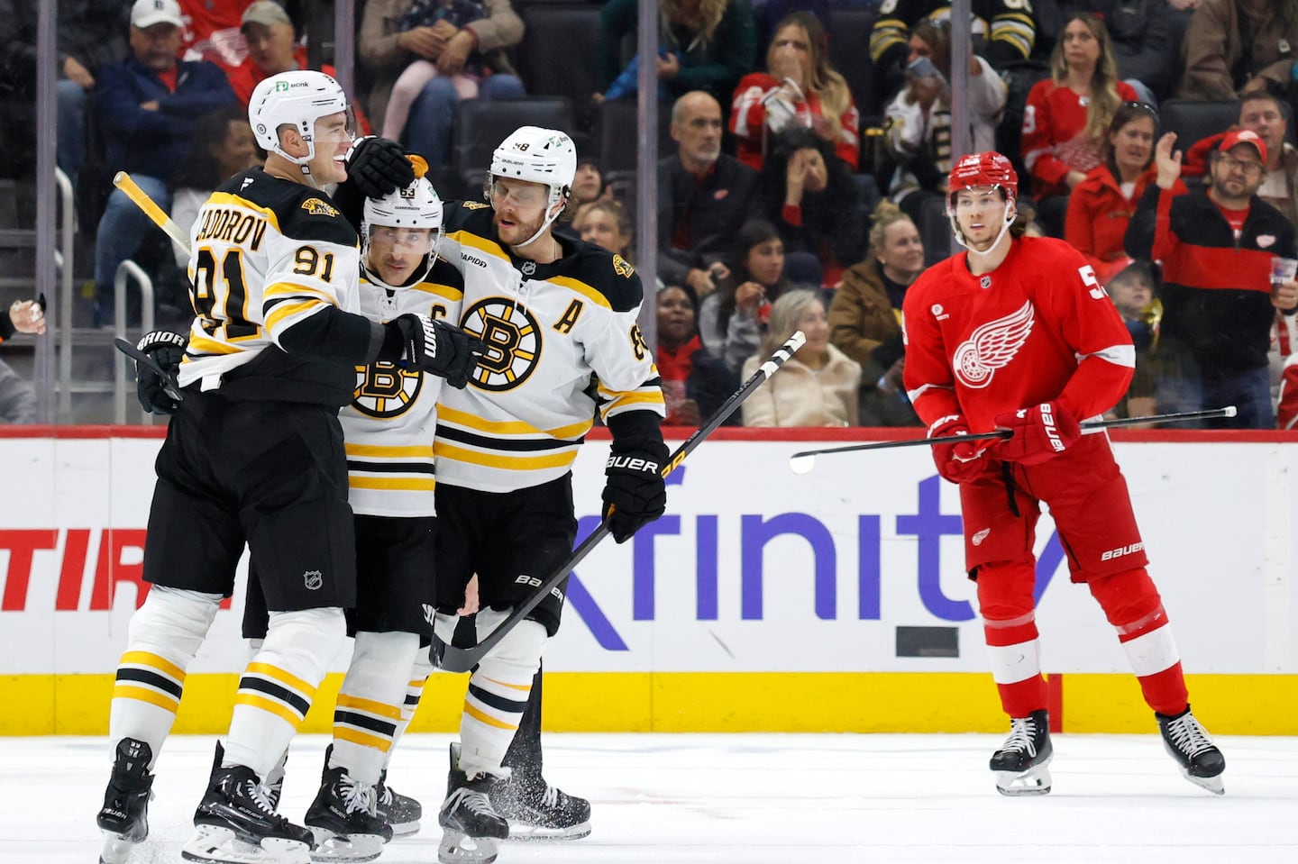 Boston captain Brad Marchand (second from left) celebrates with teammates Nikita Zadorov (91) and David Pastrnak after scoring the go-ahead goal 8:30 into the third period in Saturday's 2-1 win in Detroit. 