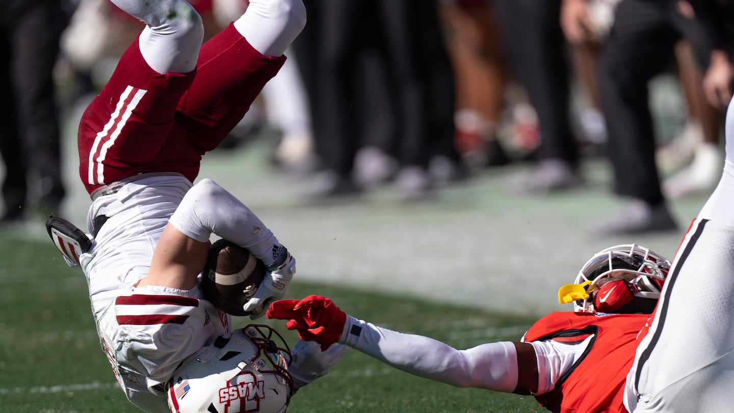 UMass wide receiver Sterling Galban (left) falls after making a catch during the first half.