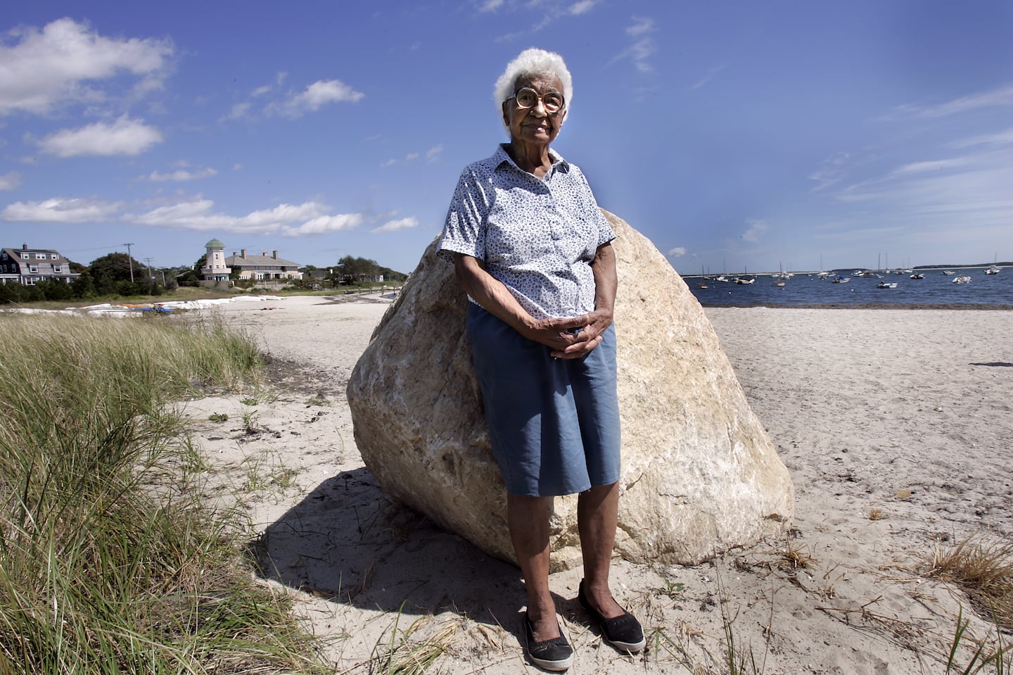 Eugenia Fortes stood on the public beach dedicated to her, the Eugenia Fortes Beach in Hyannis Port in 2004. She is honored for her "ability and courage to speak where others dared not, preserved rights of access for all," says the plaque on the other side of the rock she's leaning against.