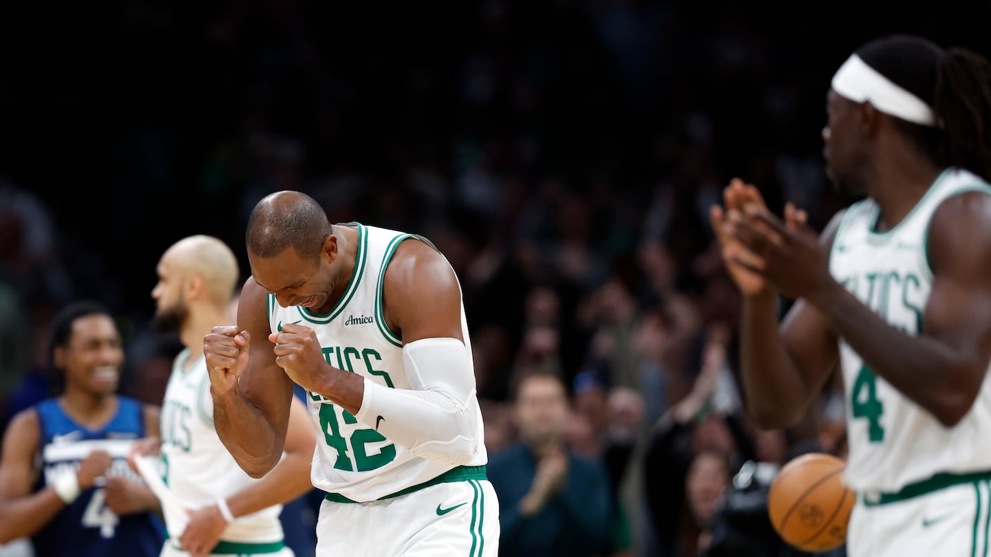 Al Horford (42) and Jrue Holiday (4) react after the Celtics held off the Timberwolves on Sunday evening for their fifth straight victory.