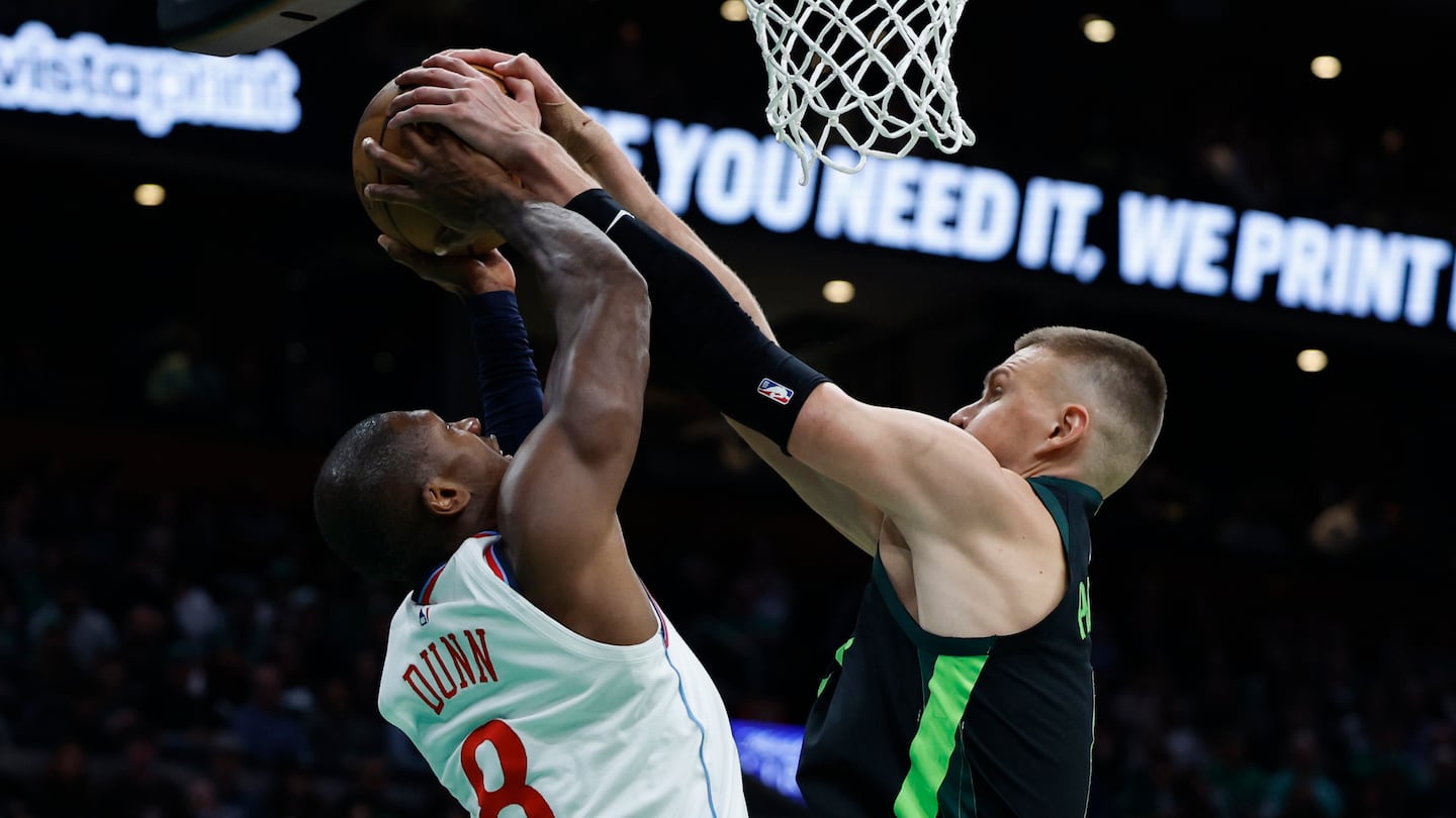 Celtics center Kristaps Porzingis (right) stuffs the Clippers' Kris Dunn during the second quarter of his season debut. Porzingis had 16 points, 6 rebounds, 2 assists, and 2 blocks.