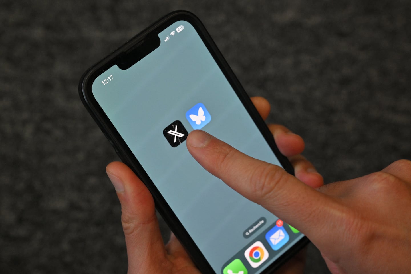 This illustration photograph taken in Brussels on Nov. 18 shows the logos of social network X (left) and Bluesky displayed on a mobile phone.