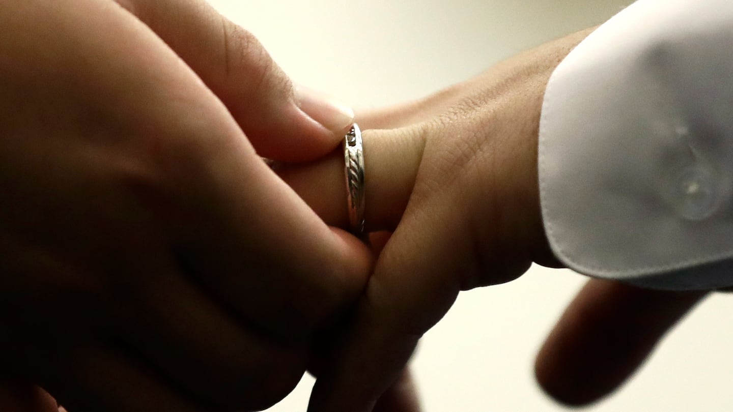 A couple exchanges wedding bands at City Hall in Philadelphia, Oct. 11, 2018. 