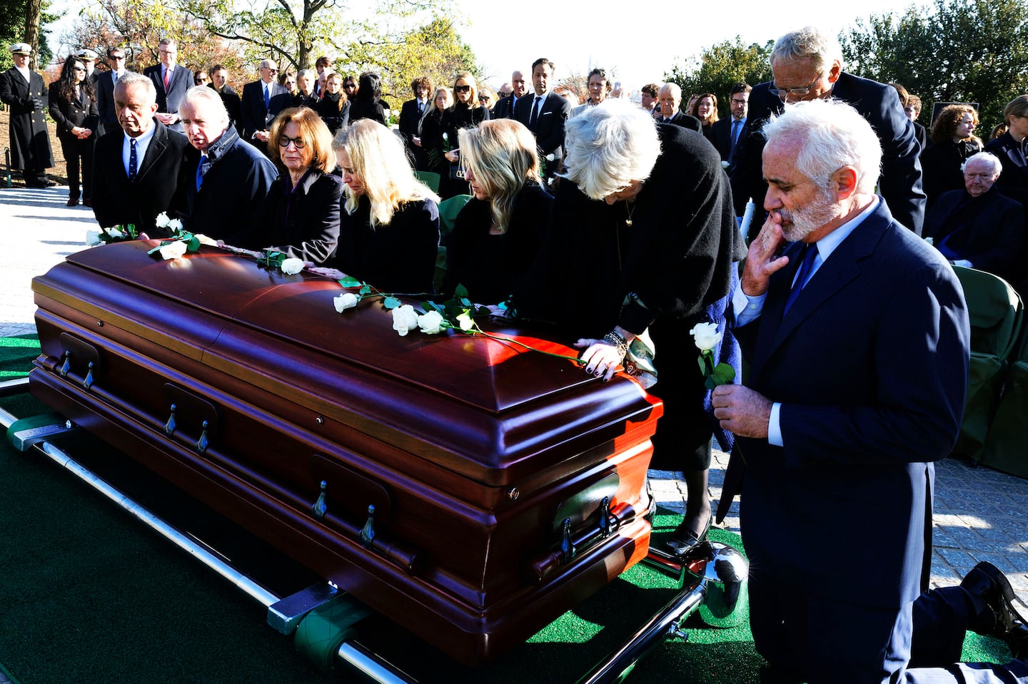 Left to right; Members of the Kennedy family, Robert F. Kennedy Jr., Chris Kennedy, Kathleen Kennedy Townsend, Kerry Kennedy, Rory Kennedy, Mary Courtney Kennedy, and Max Kennedy kneel at the casket of their mother Ethel Kennedy, during her burial, Monday, Nov. 25, 2024, at Arlington National Cemetery in Arlington, Va.