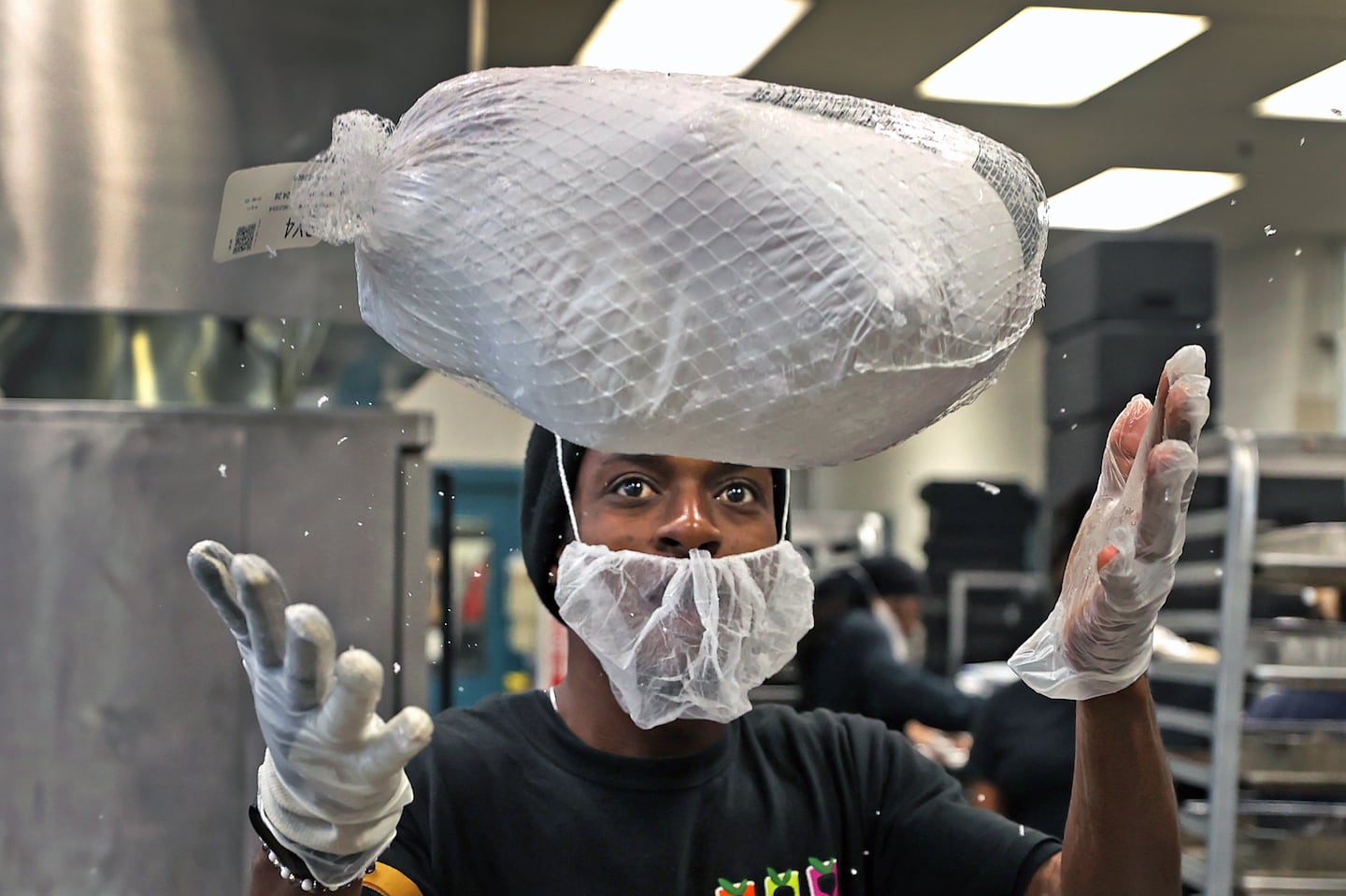 Garby handled a frozen turkey in the kitchen during Thanksgiving meal preparations at the Pine Street Inn.