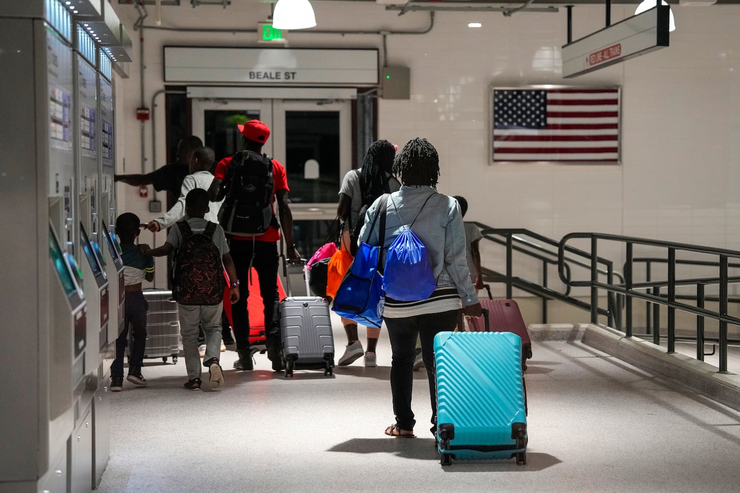 Migrant families head into a T station to head back to Logan Airport to look for a place to sleep.