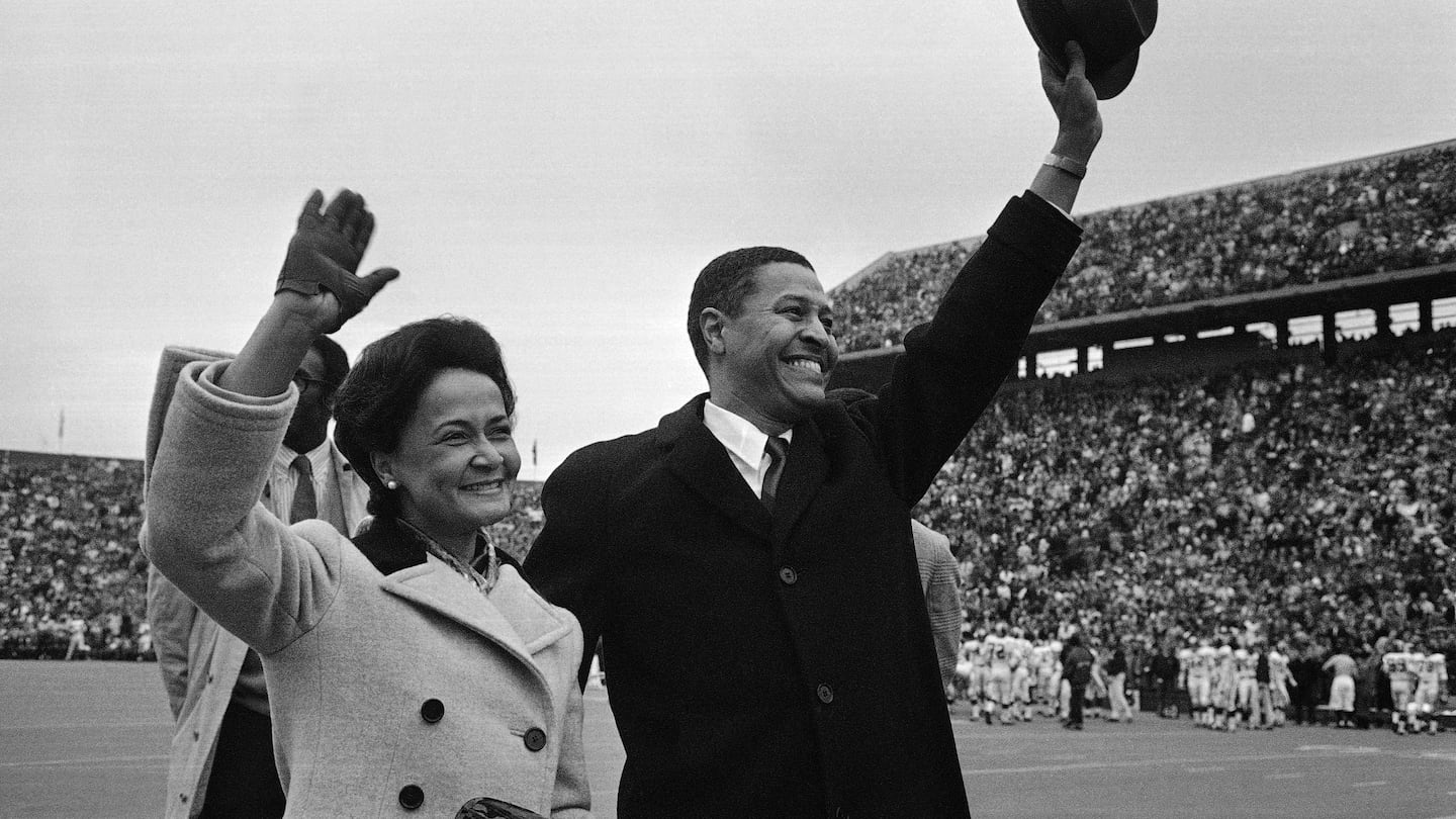 Clifton R. Wharton and wife, Dolores, acknowledge cheers from crowd as they are introduced before start of the Michigan State.