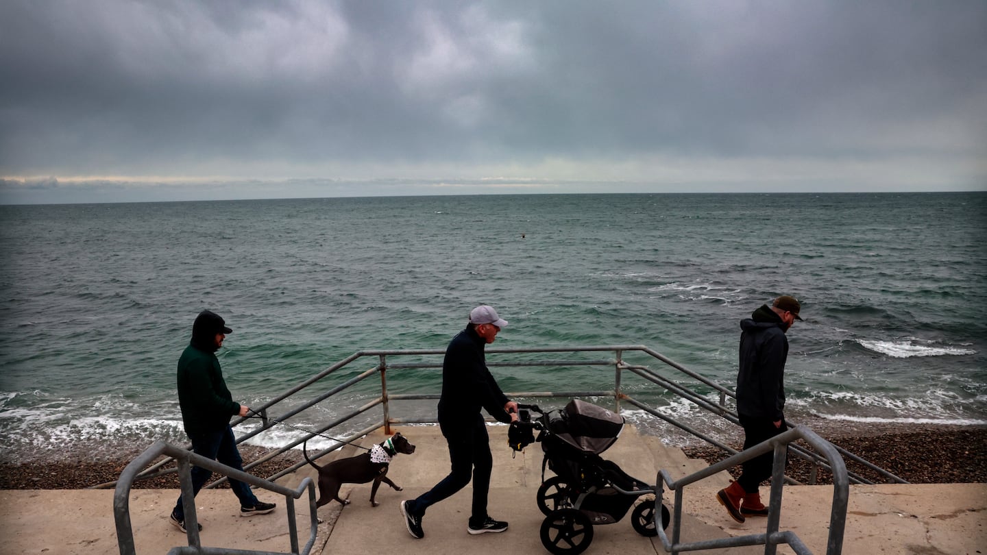 Dillon Hanratty walks with his dog, Bertie, his father, Jack, his son, Fred, and brother, Liam, on the seawall in Marshfield.